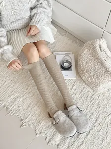 Gebreide kniekousen detailopname, gezellige winterkleding, warme beige geribbelde sokken.