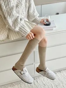 Detailopname van geribbelde gebreide kniekousen in gezellige warme beige winterkleur.