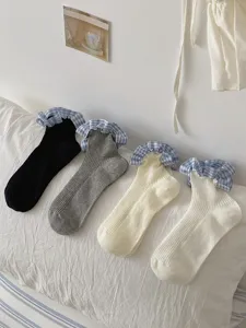 Vue détaillée de chaussettes pour femmes avec bordures à volants et motif à carreaux.