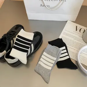 Detailed close-up of classic striped mid-calf socks displayed on clean tabletop.