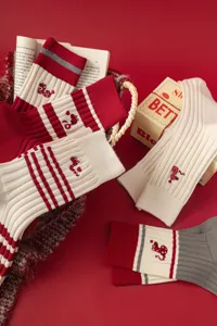 Red mid-tube knit socks for women, featuring cute snake embroidery and festive striped design.