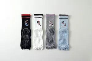 Close-up detail of cute dog pattern five-toe non-slip yoga socks with silicone grip dots.