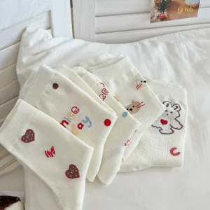 Detailed view of white cute cartoon mid-tube socks with sweet bear and heart prints for daily wear.