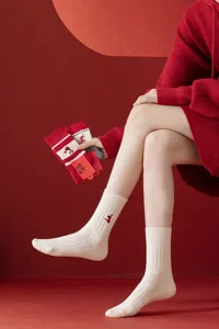 Detailed shot of women's knit mid-tube socks in cream white with red snake embroidery for new year.