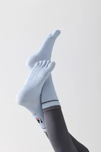 Detail view of light blue five-finger yoga socks with non-slip silicone grips.