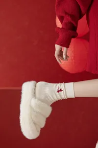 Detailed close-up of women's cream ribbed knit socks with red snake embroidery, soft cozy detail.