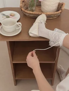 Détail de jolies chaussettes Lolita blanches à volants de dentelle avec chaussures plates.