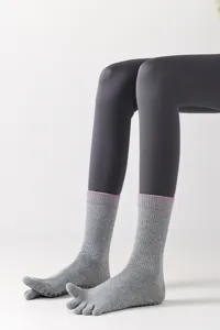 Grey cotton five-toe yoga socks with anti-slip grip sole, comfortable mid-tube active wear.