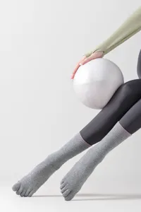 Close-up detail of grey five-toe yoga socks with split toes and pink stripes for pilates.