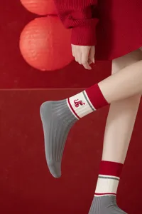 Close-up view of the knit mid-tube sock featuring a cute red snake embroidery and cozy ribbed cuff.