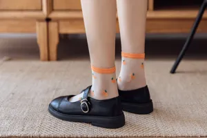 Gros plan de chaussettes transparentes en soie de verre avec motif d'orange et bord côtelé.