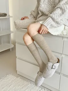 Gedetailleerd overzicht van gezellige geribbelde kniekousen voor dames in beige, winterstijl.