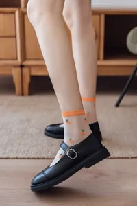 Chaussettes transparentes d'été pour femmes en soie de verre avec motif orange. Vue de détail.