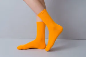 Orange crew socks for women, solid color casual wear soft mid-calf hosiery for daily fashion outfits.