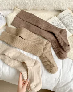Close-up detail van zachte, geribbelde fleece winter kniekousen in neutrale tinten.