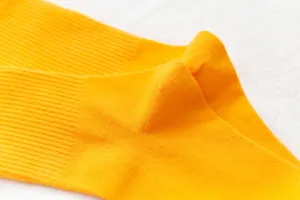 Close-up detail of bright yellow ribbed crew socks, soft knit fabric texture display.