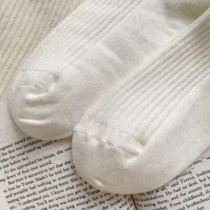 Close-up van witte geribbelde thermische sokken detail, zachte gezellige textuur voor de winter.