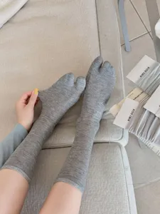 Close-up detail of grey split-toe socks, breathable cotton material, comfortable two-toe design.