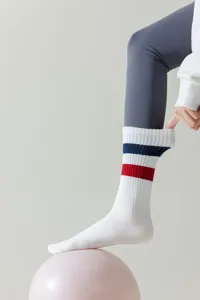 Close-up view of a white athletic long sock with blue and red stripes for yoga and fitness.