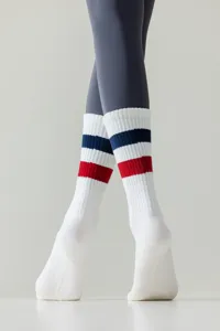 White yoga socks detail view featuring classic blue and red athletic stripes on legs