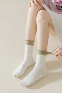 Close-up detail shot of women's mid-calf double-ribbed socks featuring green cuffs.