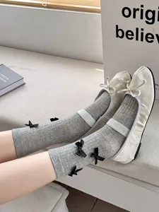 Grey ribbed mid-tube socks featuring cute black bows, delicate detail and sweet design.