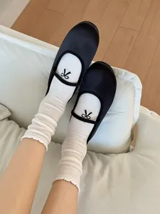 Vue de détail montrant la broderie délicate du nœud et la texture côtelée des chaussettes pour femmes.