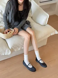 Vue détaillée de chaussettes mi-mollet blanches pour femmes avec volants et nœud, style élégant.