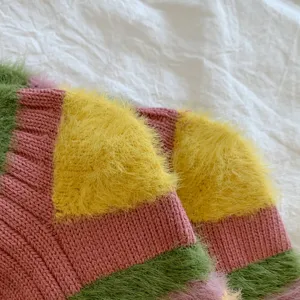 Close-up detail of soft fuzzy knit colorful striped socks, plush texture, cozy winter style.