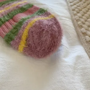 Fuzzy striped sock detail, cozy winter plush knit design, soft colorful sock close up.