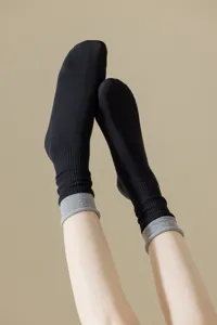 Detail view of black mid-tube socks with grey contrast folded cuffs, soft and stylish.