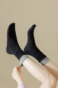 Detailed view of women's mid-tube socks with contrast double cuffs and fake two-piece style.