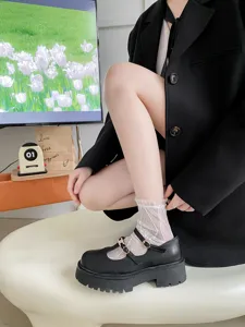 Gros plan détaillé de chaussettes transparentes en dentelle avec des chaussures Mary Jane.