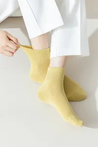 Nahaufnahme atmungsaktiver gelber Baumwollsocken mit feiner Netzstruktur und Elastizität.