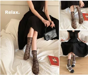 Primo piano di calzini in rete nera trasparente con simpatici cuori per un look alla moda.