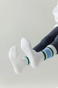 Close-up of white athletic yoga socks featuring anti-slip grip dots and striped details.