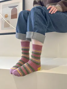 Detailed view of fuzzy striped women's mid-tube socks in cozy autumn winter style.