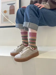 Detailed shot of fluffy striped mid-calf socks paired with stylish platform sneakers.