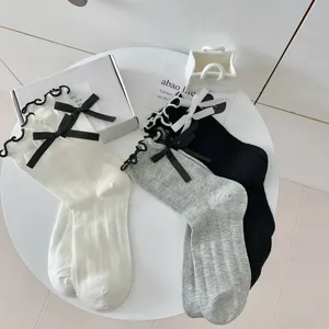 Detailed shot of Lolita sweet bow ruffle mid-calf socks in white grey and black vertical stripes.