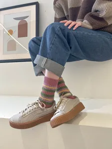Cozy fuzzy striped mid-calf socks detail shot showing colorful retro winter warmth.
