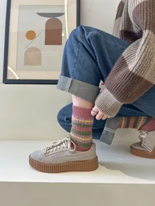Cozy fuzzy striped women socks detail view, warm winter retro mid-tube knitted hosiery style.