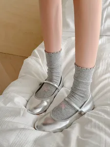 Vue détaillée de chaussettes en coton à volants pour femmes avec jolies chaussures argentées.