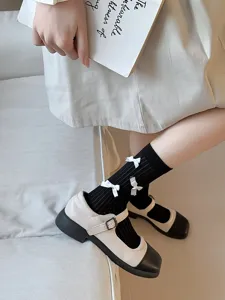 Charming black mid-calf socks with white bows for daily cute styles.
