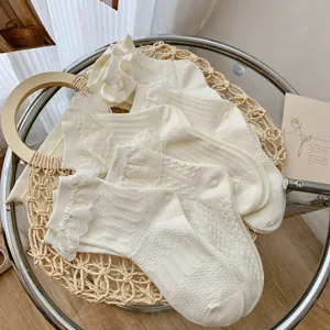 Süße japanische weiße Wadensocken mit zarten Spitzenrüschen und hübschen Punktmuster-Strickdetails.