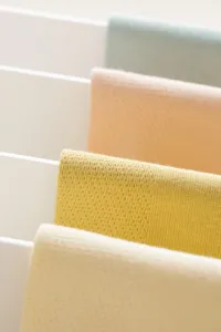Nahaufnahme von reinen Baumwoll-Mesh-Strümpfen in Pastellfarben, ordentlich an Stangen.