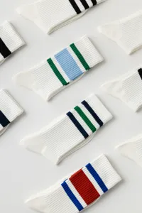 Detailed close-up shot of white athletic crew socks featuring colorful striped ribbed cuffs.