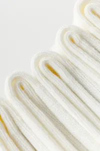 White yoga socks detail view, premium ribbed knit fabric, soft stretch athletic wear.