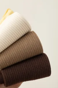 Close-up detail of stacked ribbed knit crew socks in neutral earth tones for women.