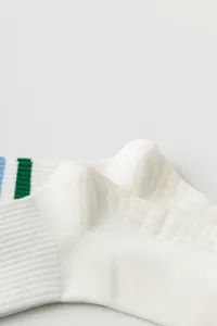 Close-up detail shot of white women yoga pilates non-slip grip socks with color stripes.