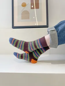 Cozy plush fuzzy mid-calf socks with colorful striped design, soft winter warm style shot.